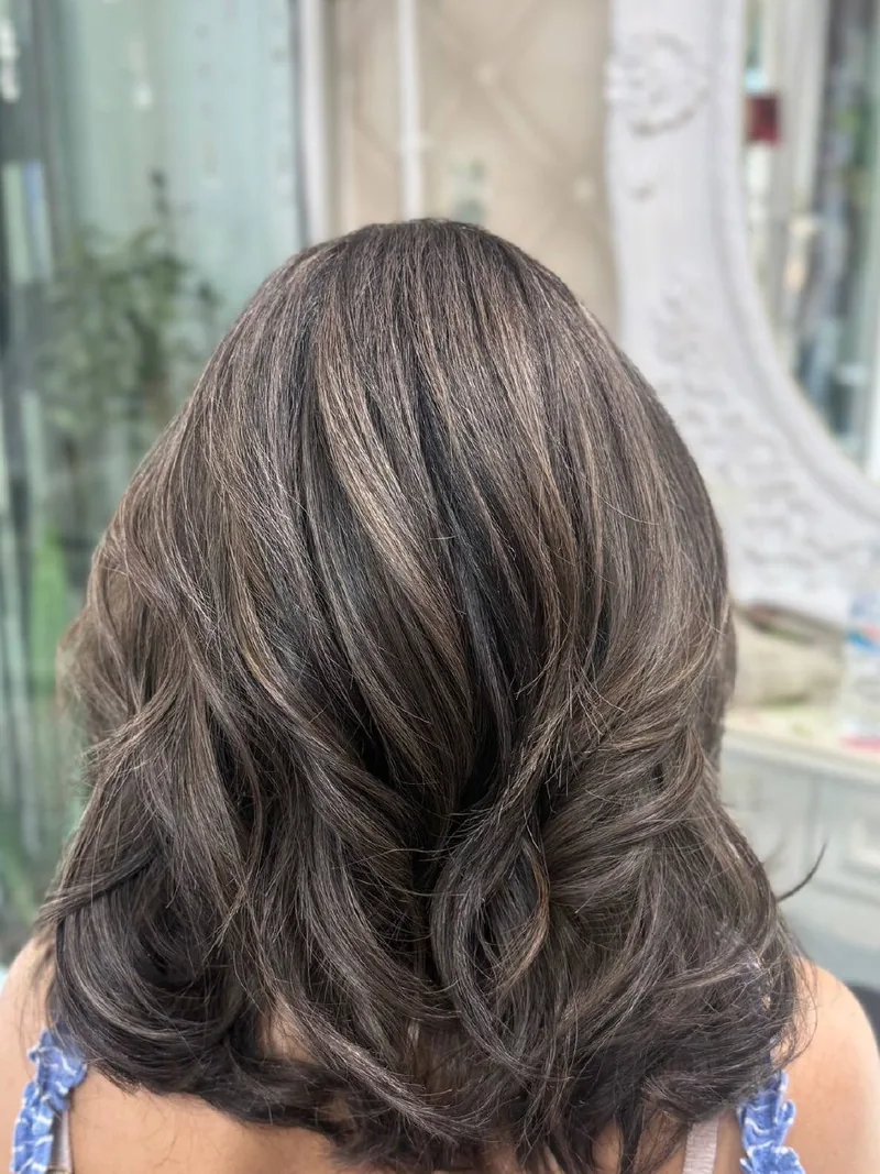 Oilly Hair Salon Bangkok 受损发修护后 - 有光泽、层次感自然的灰棕色，与原生发根自然融合