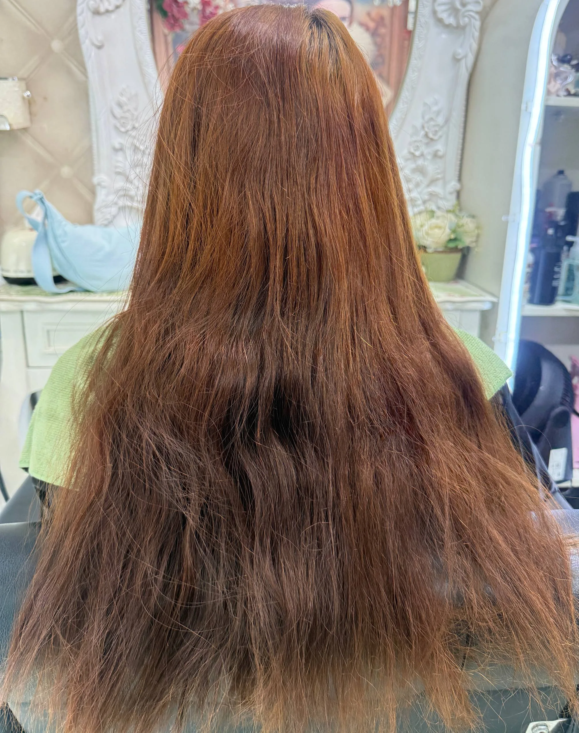 Oilly Hair Salon 曼谷沙吞补色矫正前 — 由永久离子烫、自己漂发与反复深染造成的多层染色叠加受损发，发尾干燥毛糙，红铜色调不均匀