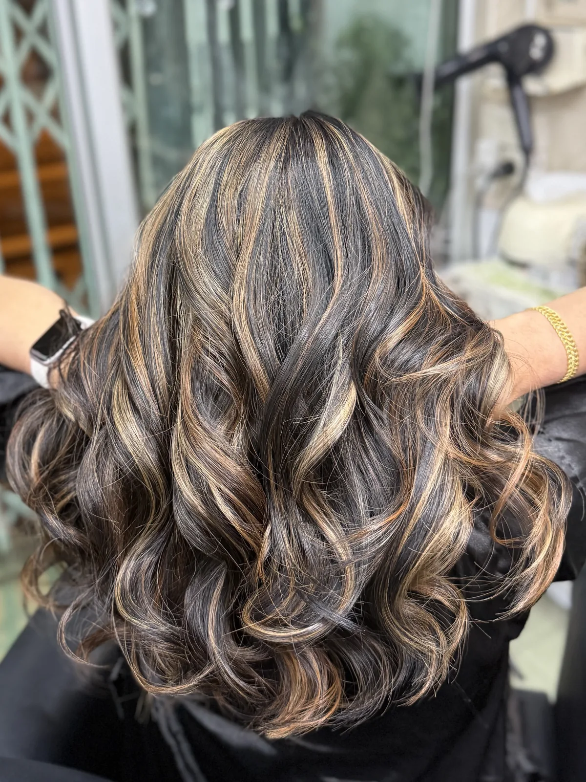 Long curly hair with shimmer highlights at Oilly Hair Salon Bangkok
