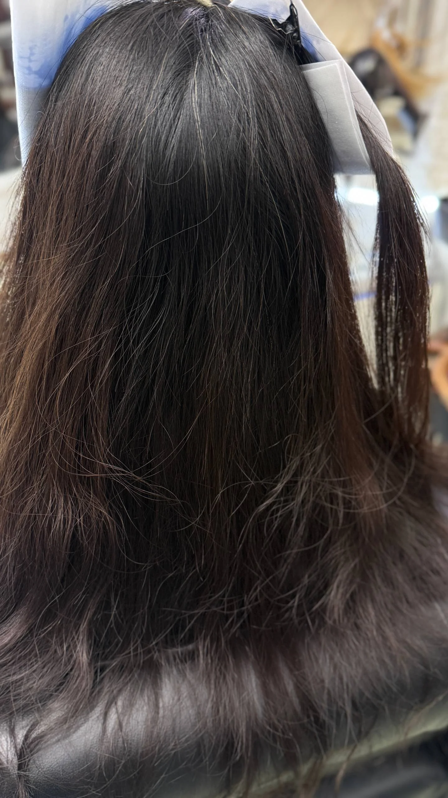 Before dark dyed Asian hair with visible grey roots before grey blending balayage in Bangkok