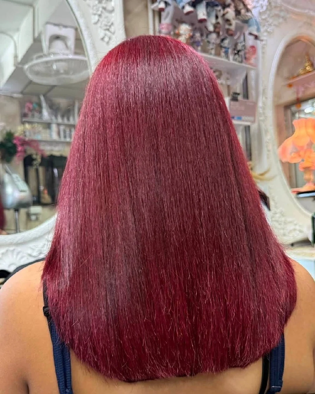Back view of glossy cherry red blonde hair after a no-bleach color service in Bangkok