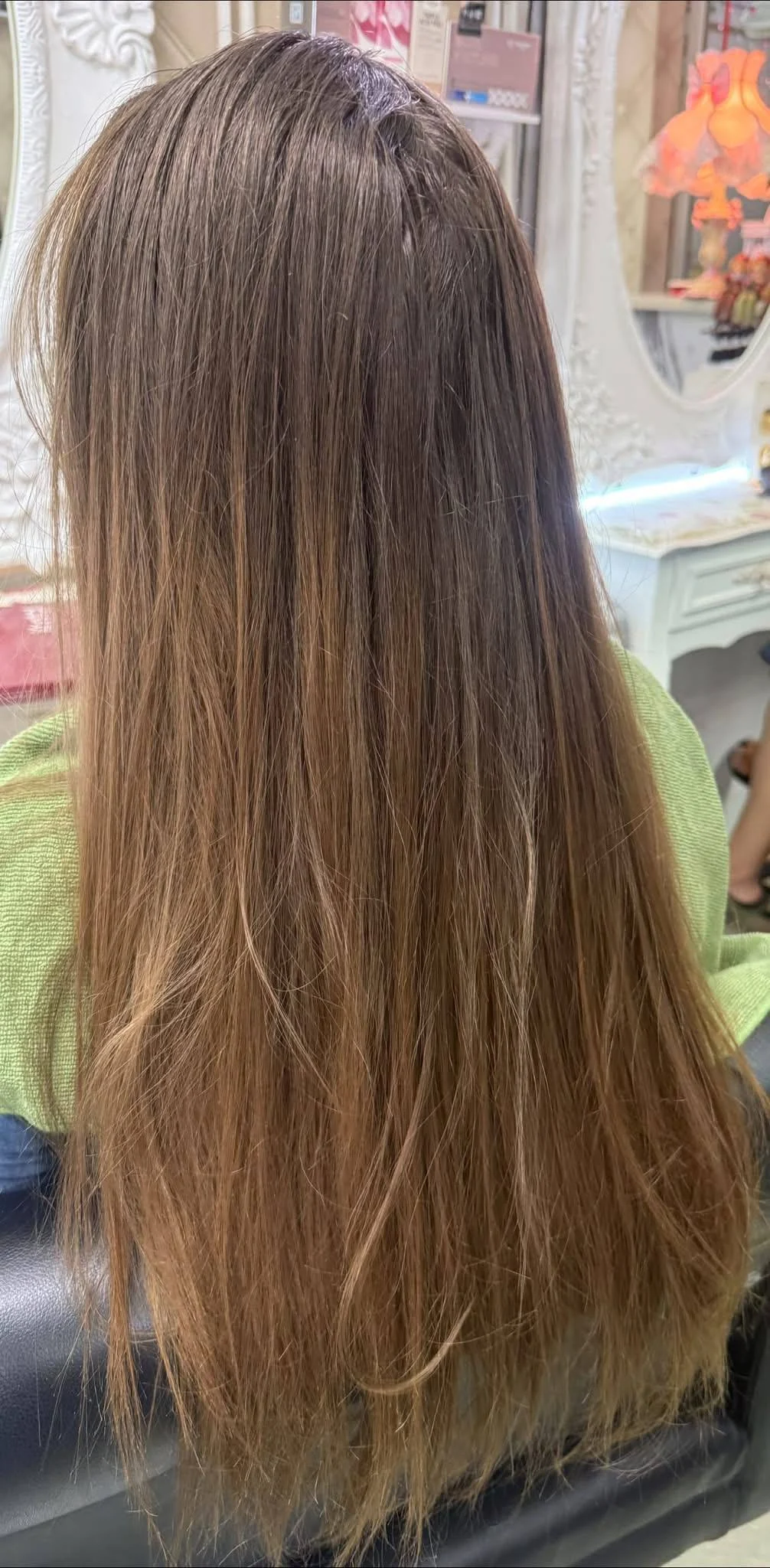 Before photo of European hair with visible grey regrowth and uneven warm lengths before no-bleach ombre color