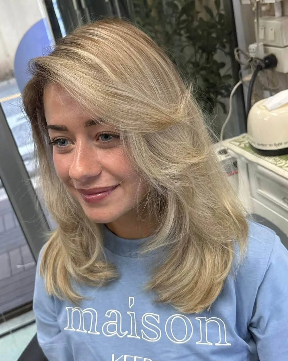 Front result of bright blonde AirTouch Balayage with soft roots and face-framing layers at Oilly Hair Salon Bangkok