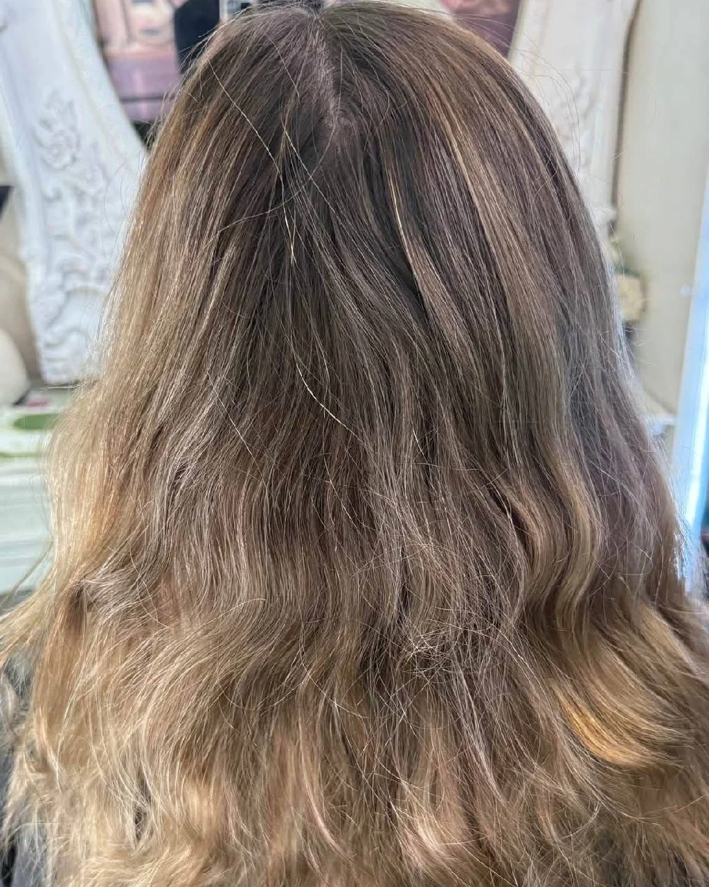Back view before AirTouch Balayage showing deeper regrowth and previous warm uneven highlights at Oilly Hair Salon Bangkok