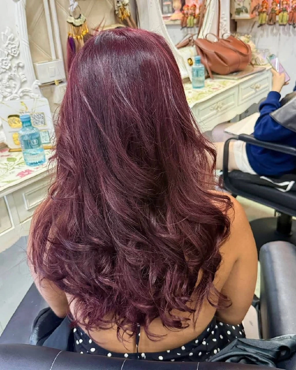 Back result of deep cherry wine red hair with long layered movement at Oilly Hair Salon Bangkok