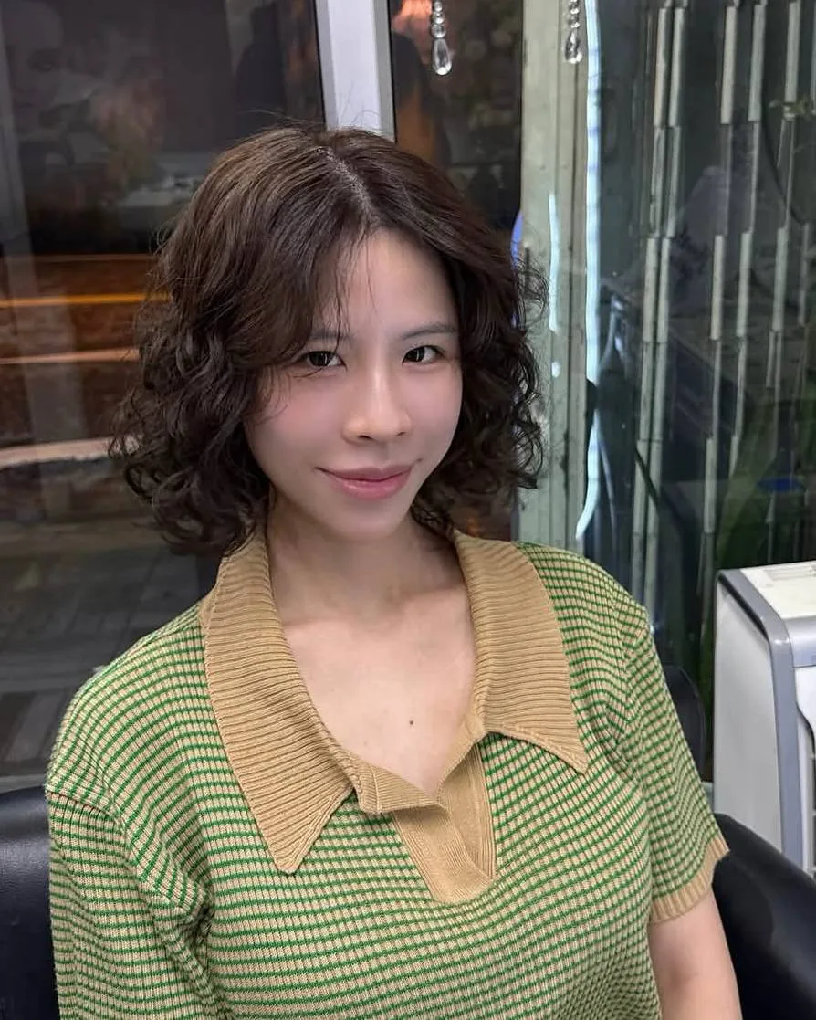 Korean S-wave digital perm with face-framing waves and muted brown toner in Bangkok, front view